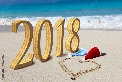 Happy new year card. Two New Year's caps of Santa Claus on beach and on sand heart is drawn and inscription 2018