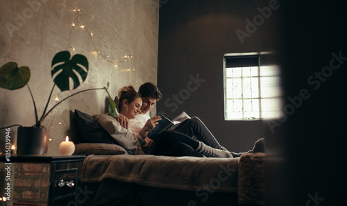 Couple on bed reading book