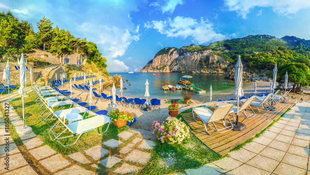 Sunbeds and umbrella on the beach in Corfu Island, Greece.