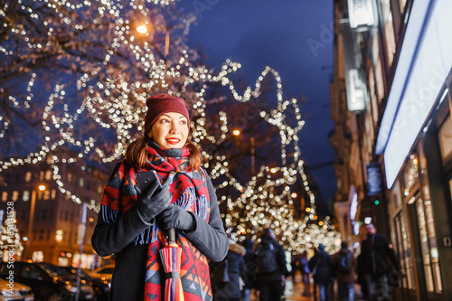Young woman tourist standing at illuminated alley christmas decoration