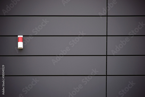 Metallfassade mit Alarmanlage / Eine moderne Hausfassade aus Metallpaneelen mit einer Warnleuchte. photo
