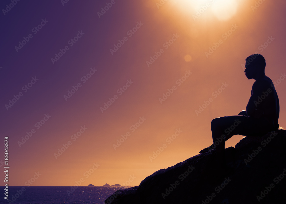 Mann auf Fels bei Sonnenuntergang