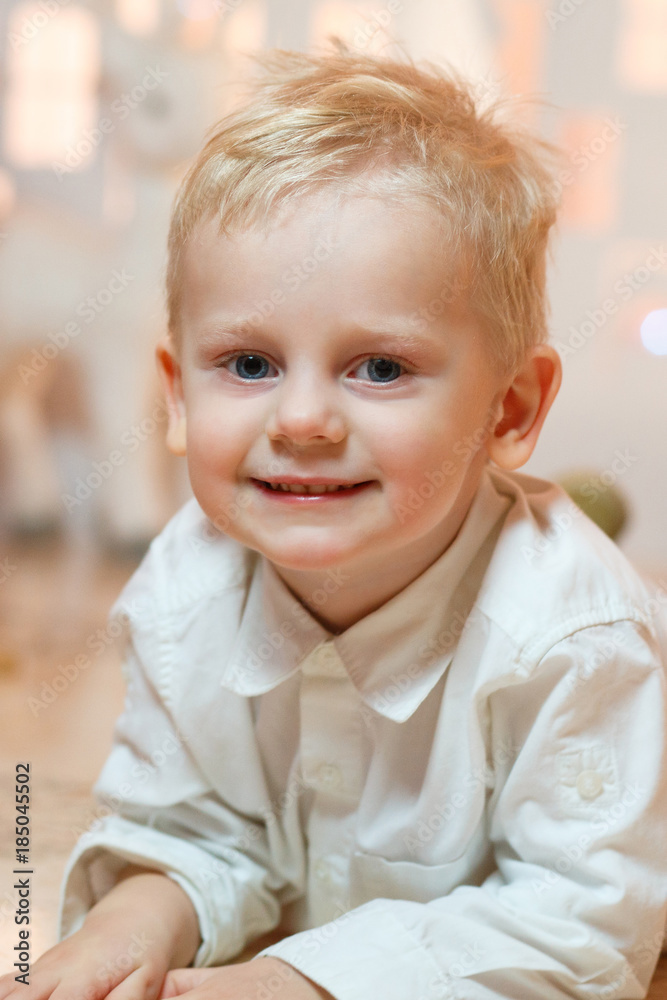 Cute blonde hair little boy near christmas toy paper houses Cute blonde hair little boy near christmas toy paper houses