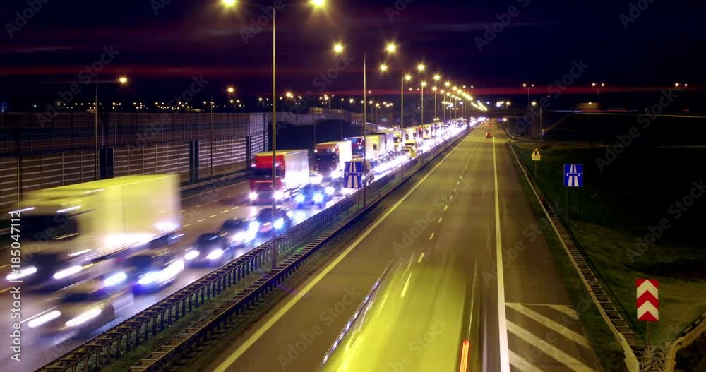 Highway traffic at night in time-lapse animation. Lots of trucks and cars on a crowded road in rush hour.