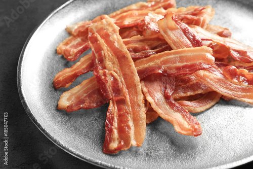 Cooked bacon rashers on plate, closeup