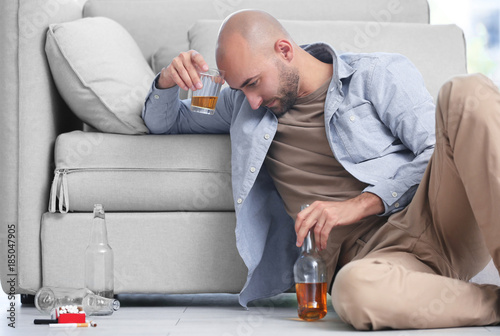 Drunk man sitting on floor ...