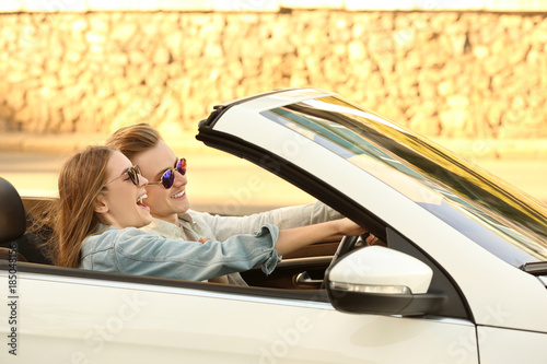 Happy young couple in car o...