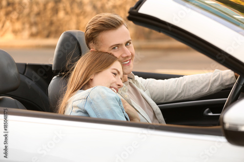Happy young couple in car o...