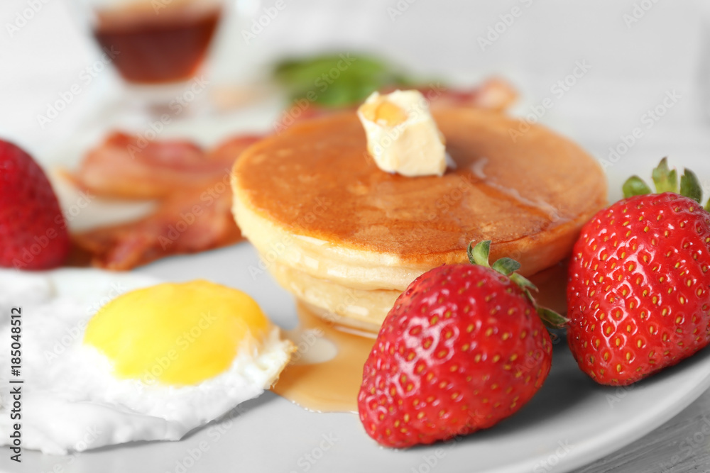 Tasty breakfast with pancakes and fried egg on table