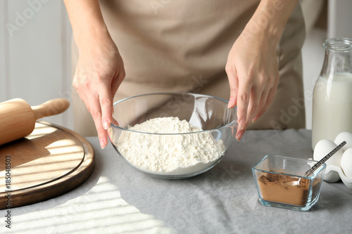 Woman preparing dough for cinnamon buns in kitchen