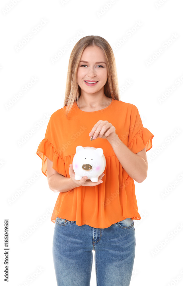 Young woman putting coin into piggy bank on white background Young woman putting coin into piggy bank on white background