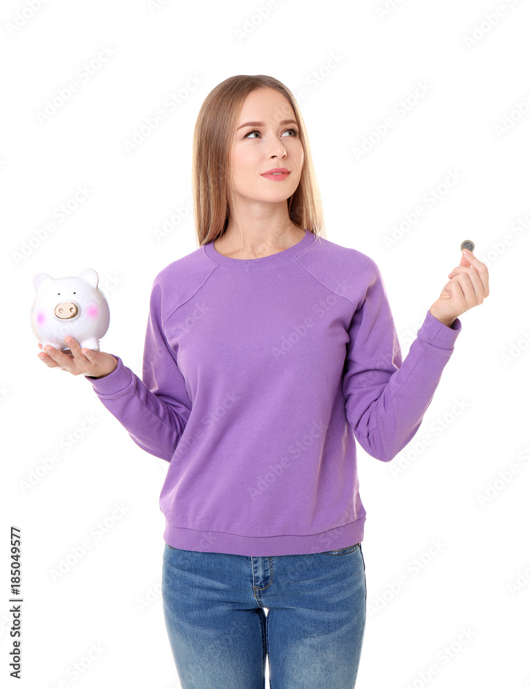 Obraz premium Young woman holding piggy bank and coin on white background
