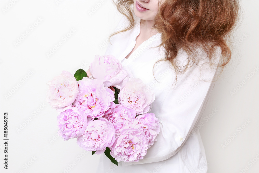 Woman holding pink peonies.