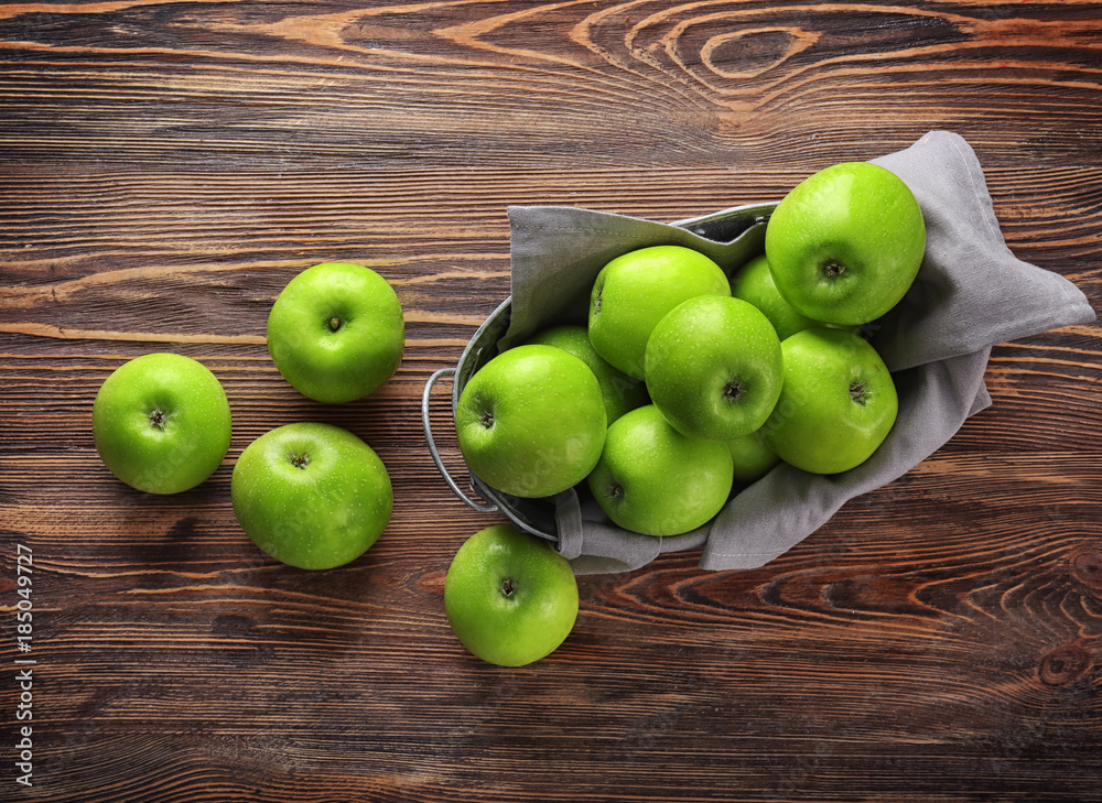 Basket with fresh green apples on wooden background Basket with fresh green apples on wooden background
