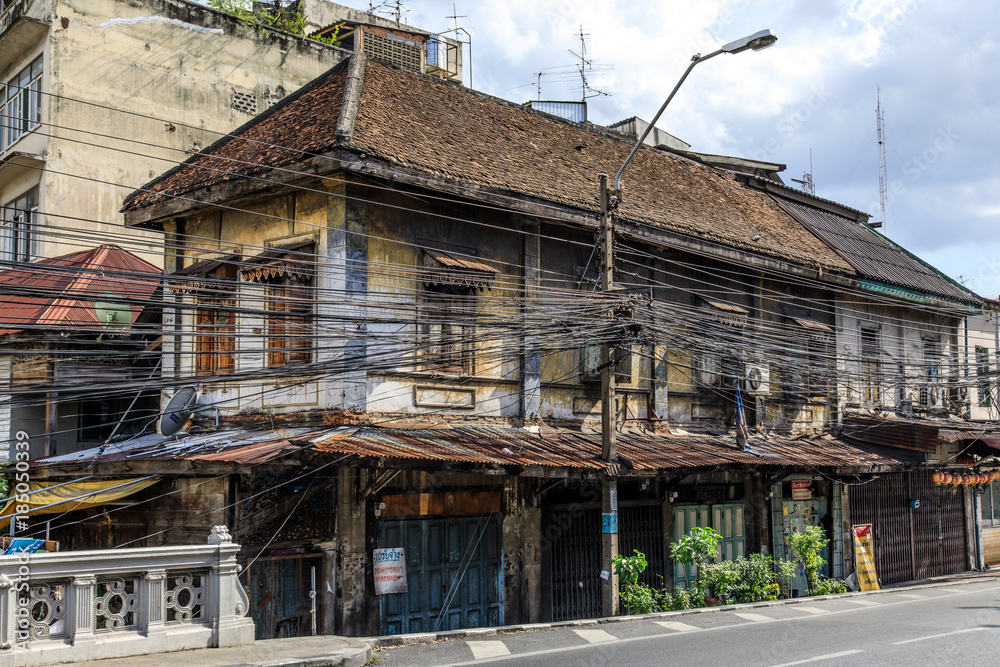 Street view of an authentic, old fashioned house with ancient electricity  in Thailand, Southeast Asia