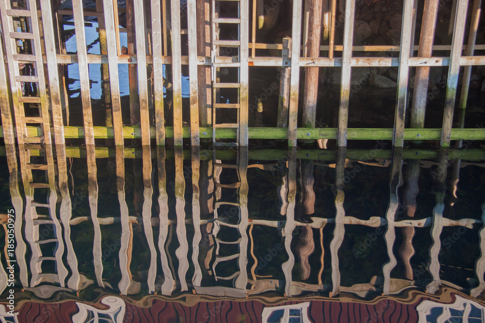 Abstract impression – reflective closeup of wooden fishermen houses built over the sea at the Lofoten islands, Norway
