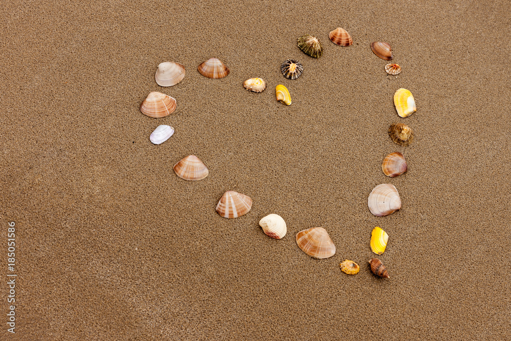 Heart shape in the beach sand made from shells Heart shape in the beach sand made from shells