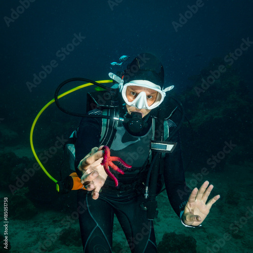 The diver holds the starfish