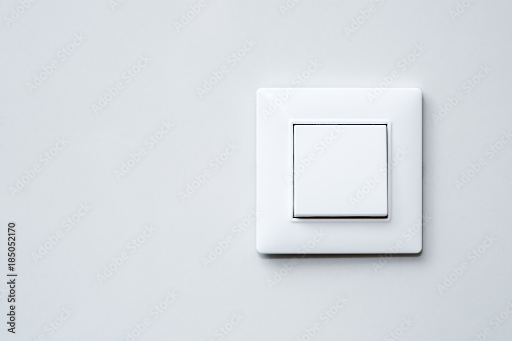 a light switch on gray wall. a light switch on gray wall.