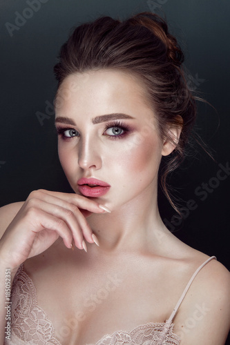 Glamour portrait of beautiful woman model with fresh daily makeup and romantic wavy hairstyle. Fashion shiny highlighter on skin  sexy gloss lips make-up and dark eyebrows.