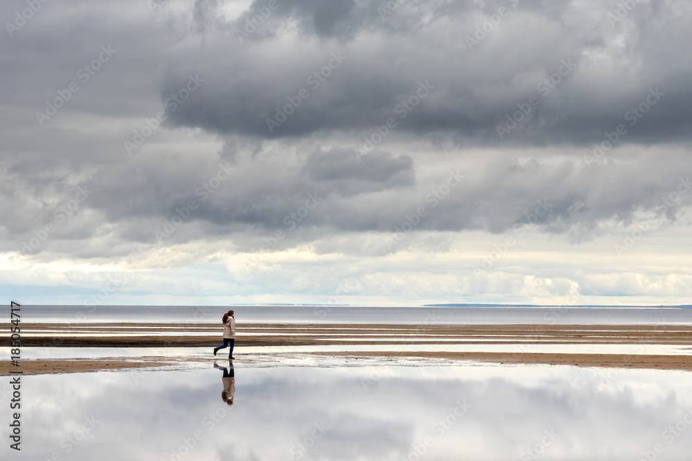 Woman on the beach run, cloudy weather Woman on the beach run, cloudy weather
