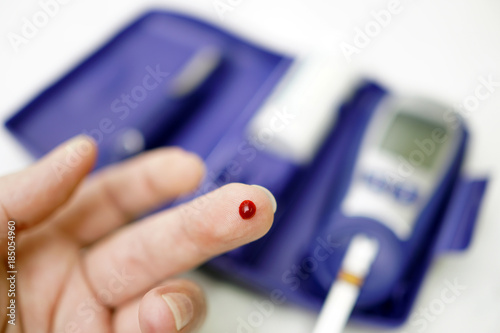 A medical test, checking a drop of blood on the sugar level.