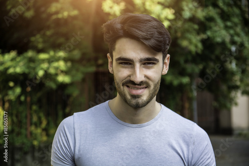 Handsome young man outdoor looking at camera, smiling