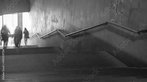 Time Lapse of black and white pictures of walking people on the stairs. Camera zoom out