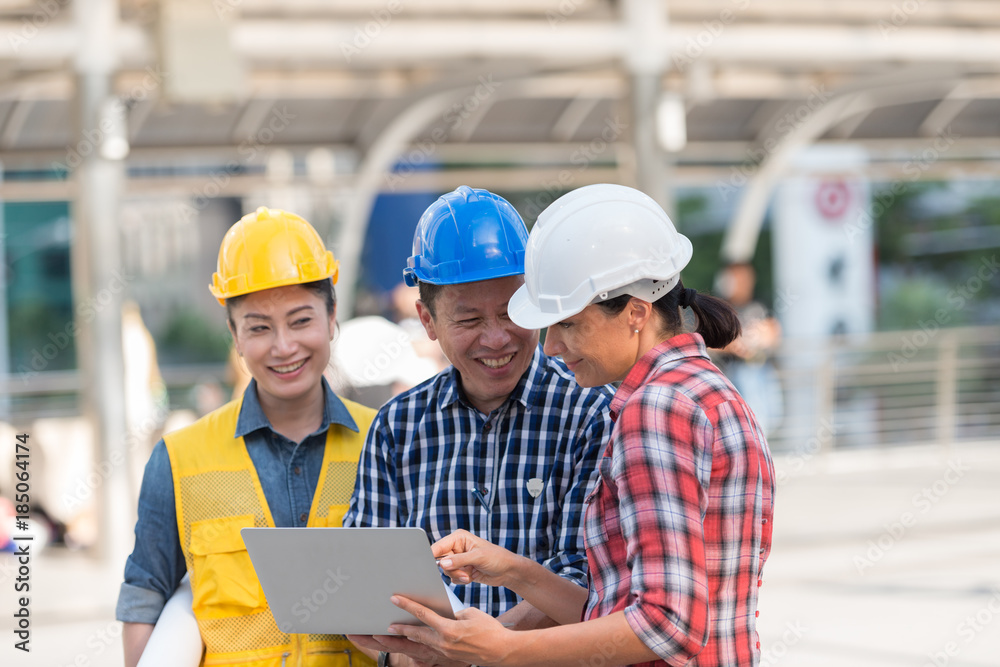 Asian engineers group consult construction on site building working while holding laptop and blueprint paper. in city background. teamwork concept. Asian engineers group consult construction on site building working while holding laptop and blueprint paper. in city background. teamwork concept.
