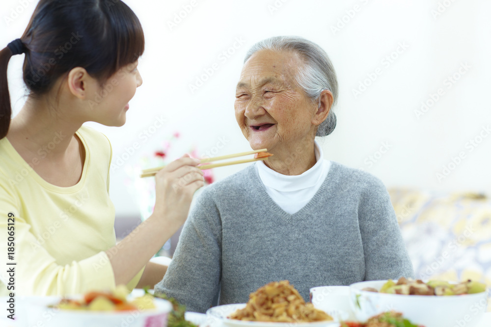 young asian woman having meal with her grandmother young asian woman having meal with her grandmother