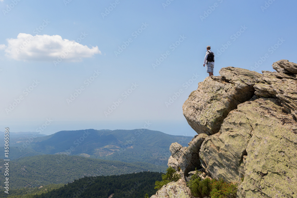 Tourist man on top of high mountains of peninsula Sithonia