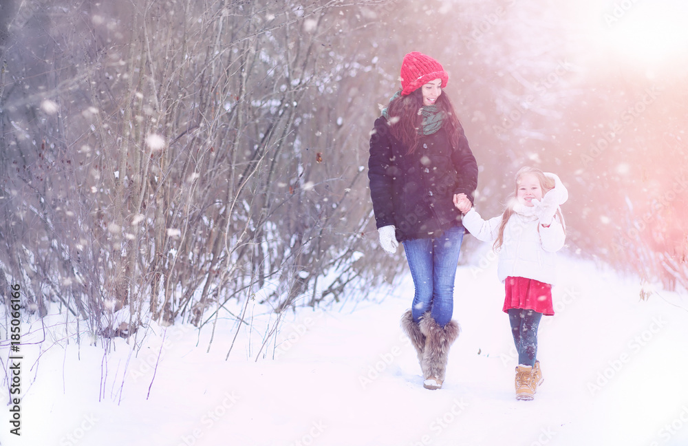 A winter fairy tale, a young mother and her daughter ride a sled A winter fairy tale, a young mother and her daughter ride a sled