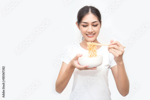Young beautiful asian woman eating yummy hot and spicy instant noodle using chopsticks isolated on white background. Asian girl servile end of the month with cheap food.