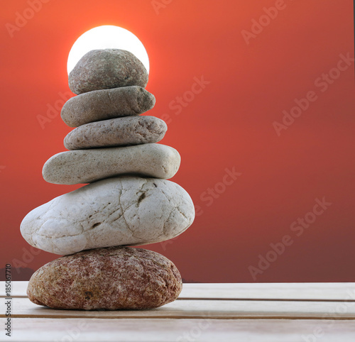 Balance Stones stacked to pyramid in the sunset background and have copy space.