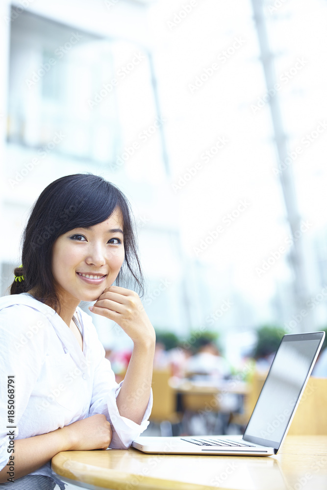 pretty Asian college student in library