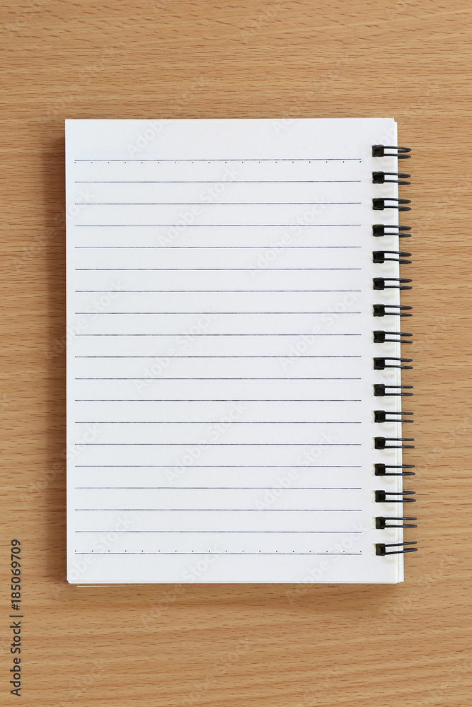 blank of notebook is placed on the brown wood table. blank of notebook is placed on the brown wood table.