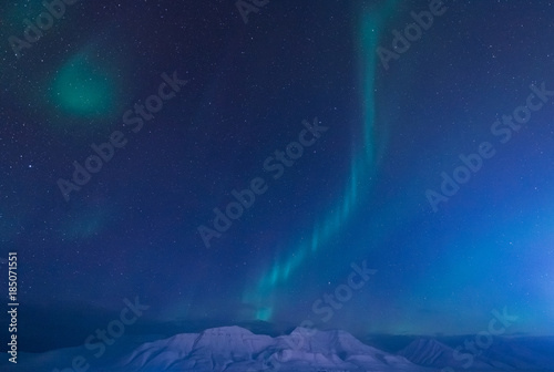 The polar arctic Northern lights aurora borealis sky star in Norway Svalbard in Longyearbyen city the moon mountains