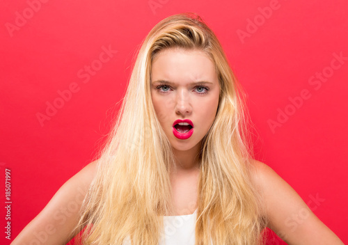 Unhappy young woman on a solid background