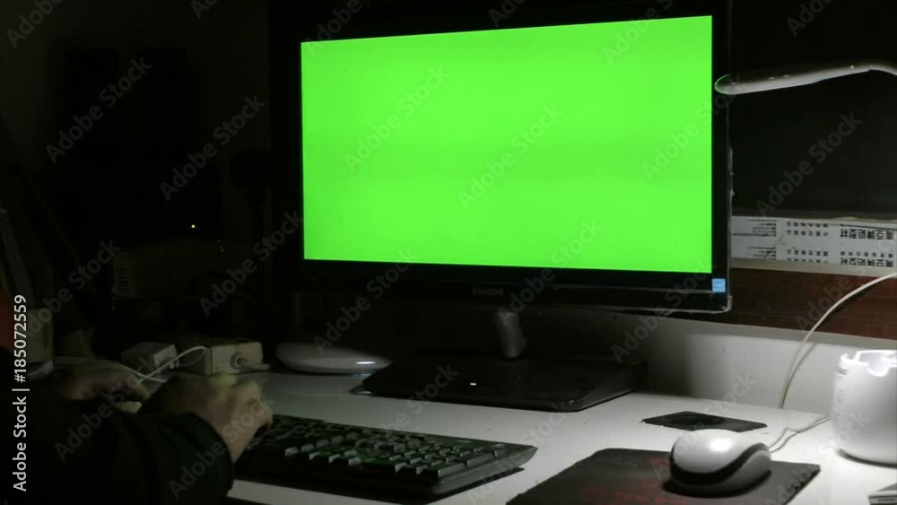 A person is operating a computer at night A person is operating a computer at night