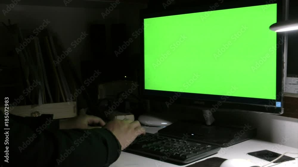A person is operating a computer at night A person is operating a computer at night