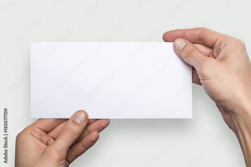 Fototapeta premium Mockup horizontal flyer empty blank white holds the man in his hand. Isolated on a gray background