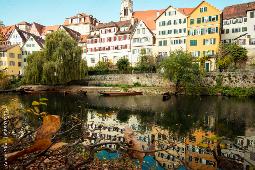 view of the river, walls and buildings of the historical part of the city of tübingen in the autumn