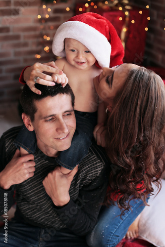 beautiful happy family posing near Christmas tree