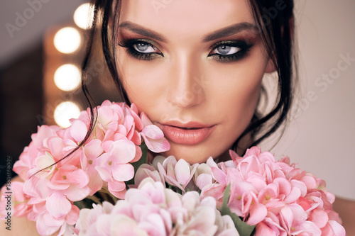beautiful woman with dark hair and evening makeup with flowers © dariyad