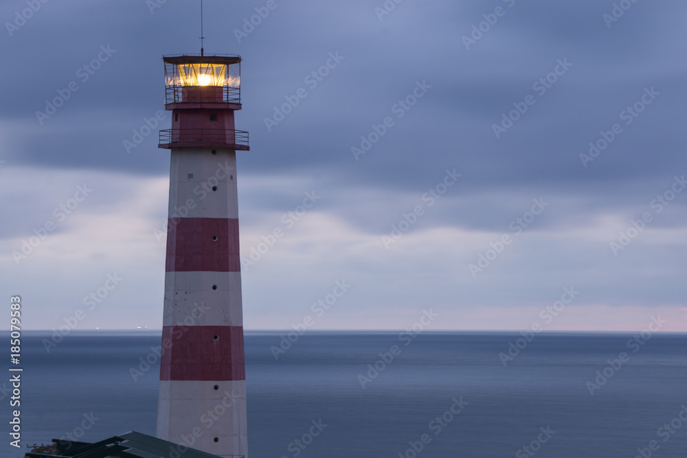 Lighthouse searchlight beam through marine air