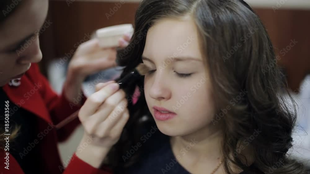 Master makeup artist at the beauty salon does makeup girl teenager Master makeup artist at the beauty salon does makeup girl teenager