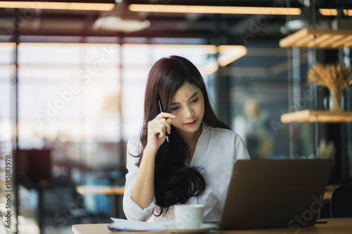 Young business woman using on the laptop while sitting at her working place. 