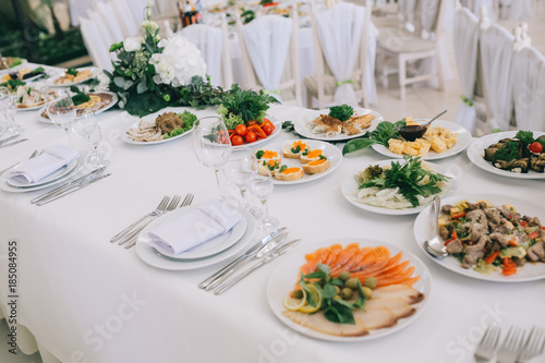 Decorated wedding table with food, drink, appliances and flowers.