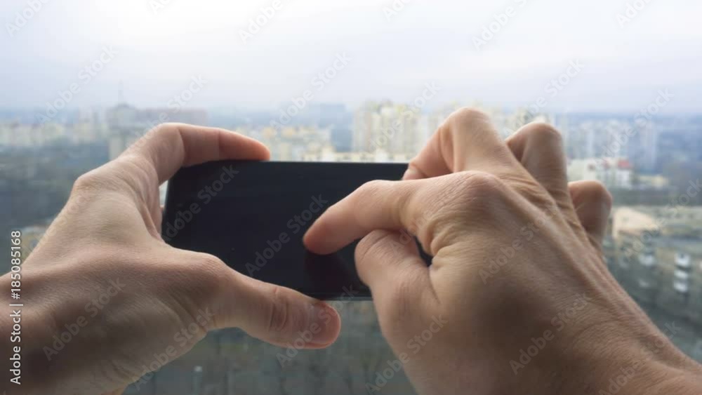 Close-up shot of man texting on smart phone against cityscape Close-up shot of man texting on smart phone against cityscape