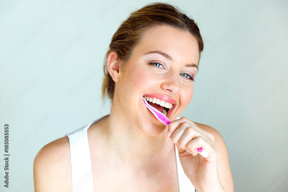Pretty young woman brushing her teeth in the bathroom at home. Pretty young woman brushing her teeth in the bathroom at home.